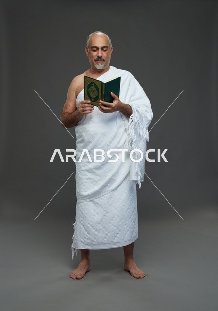رجل سعودي بملابس الإحرام يقرأ القرآن الكريم في الاستوديو