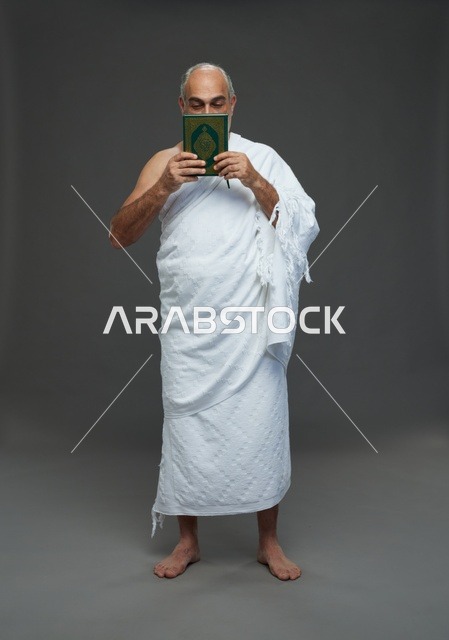 رجل سعودي بملابس الإحرام يقرأ القرآن في استوديو