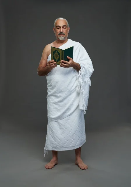 رجل سعودي بملابس الإحرام يقرأ القرآن الكريم في استوديو
