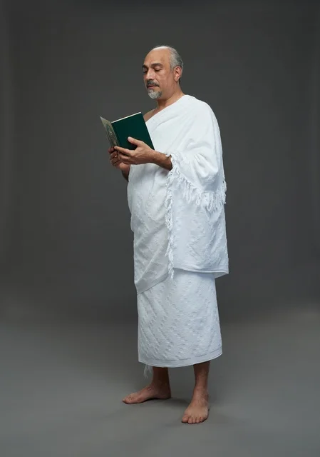 رجل سعودي بملابس الإحرام يقرأ القرآن في استوديو