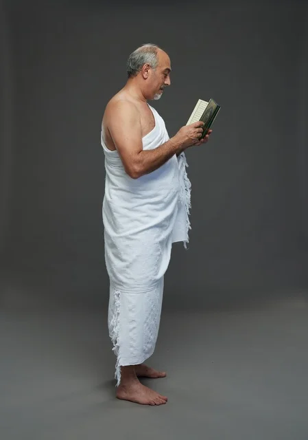 رجل سعودي بملابس الإحرام يقرأ القرآن الكريم