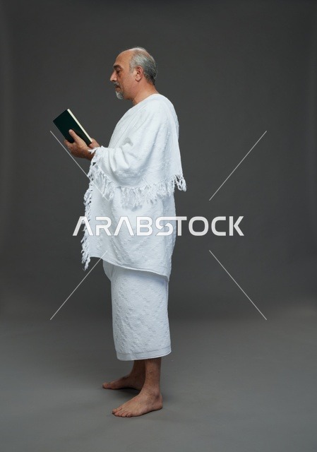 رجل سعودي بملابس الإحرام يقرأ القرآن الكريم في الاستوديو