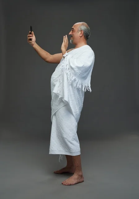 رجل سعودي بملابس الإحرام يلتقط سيلفي بالهاتف