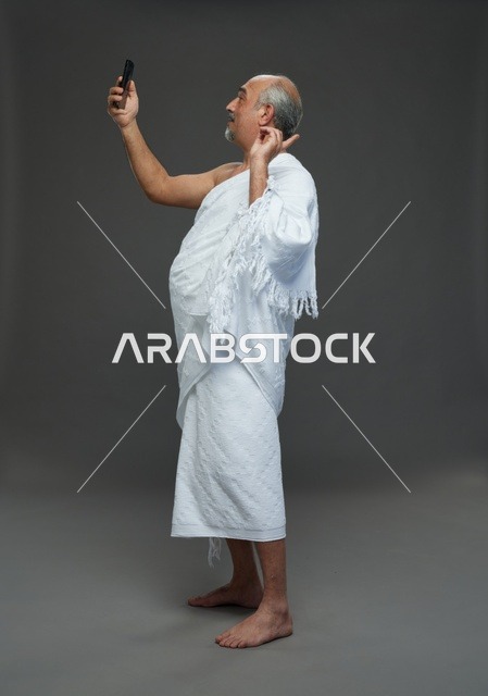 رجل سعودي بملابس الإحرام يلتقط سيلفي بالهاتف