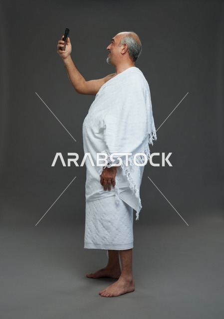 رجل سعودي بملابس الإحرام يلتقط سيلفي بالهاتف