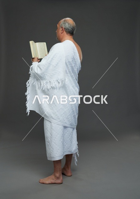 رجل سعودي بملابس الإحرام يقرأ القرآن الكريم