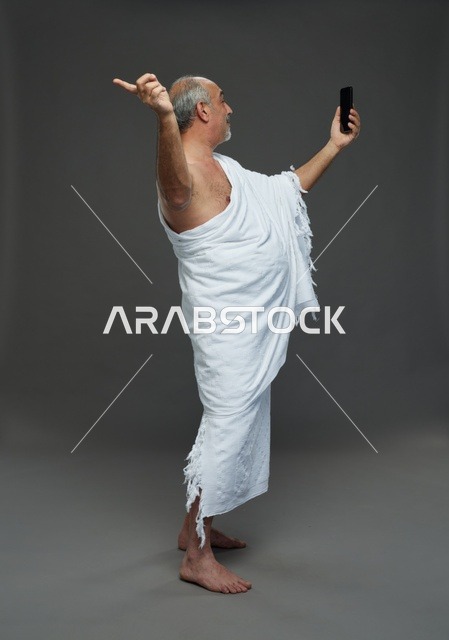 رجل سعودي بملابس الإحرام يلتقط سيلفي بالهاتف