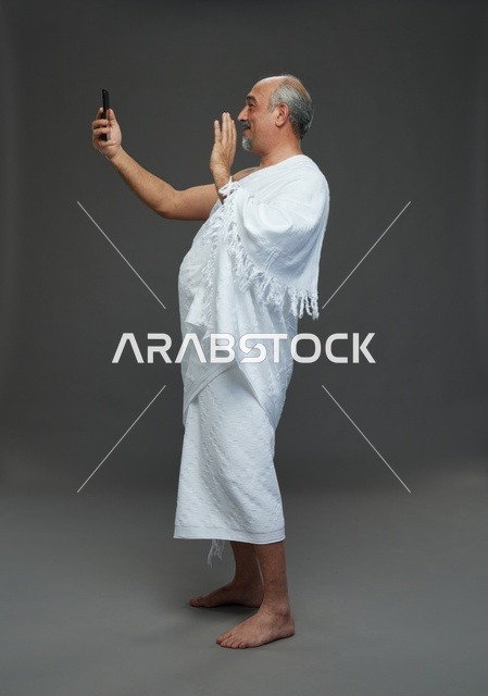 Saudi Man in Ihram Using Smartphone Video Call