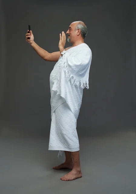 Saudi Man in Ihram Using Smartphone Video Call