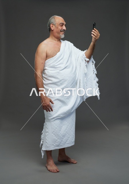 رجل سعودي بملابس الإحرام يلتقط سيلفي بالهاتف
