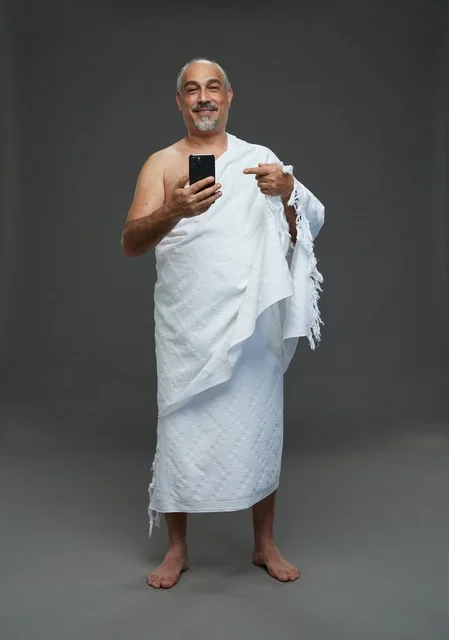 Saudi Man in Ihram Pointing at Smartphone