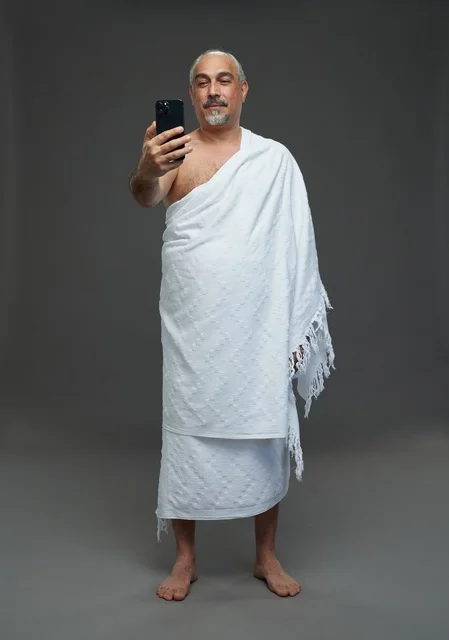 رجل سعودي بملابس الإحرام يلتقط سيلفي بالهاتف الذكي