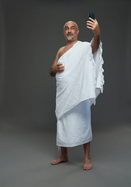 Saudi Man in Ihram Taking Selfie on Grey Background