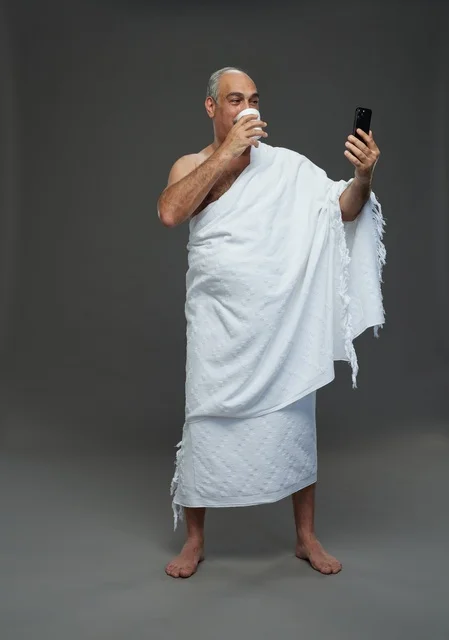 Saudi Man in Ihram Taking Selfie on Grey Background