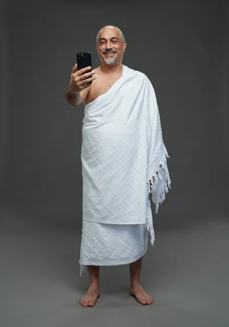 رجل سعودي بملابس الإحرام يلتقط سيلفي بالهاتف