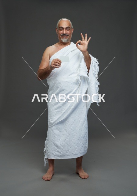 رجل سعودي بملابس الإحرام يحمل بطاقة فارغة