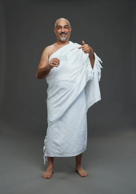 رجل سعودي بملابس الإحرام يحمل بطاقة فارغة في استوديو