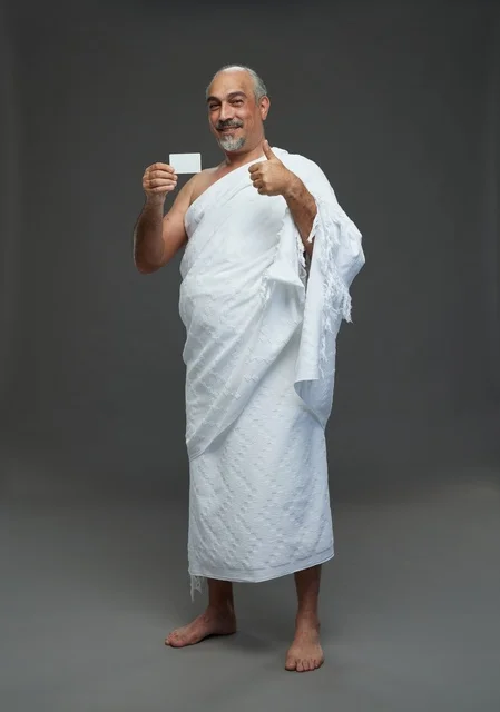 رجل سعودي بملابس الإحرام يحمل بطاقة فارغة للإعلان