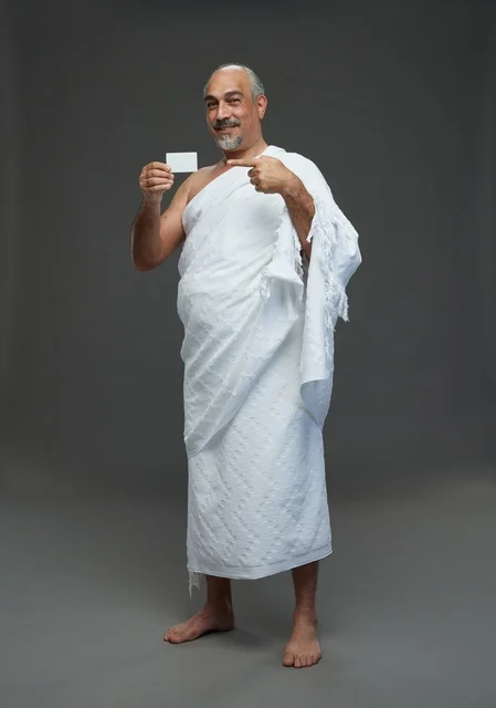 Saudi Man in Ihram Holding Blank Card on Grey