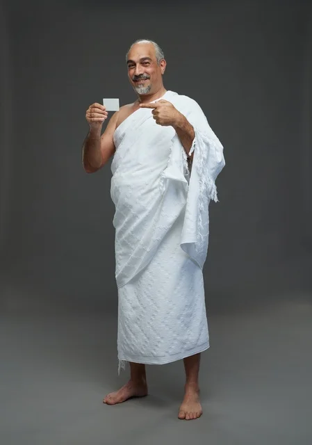 Saudi Pilgrim in Ihram Holding Blank Card on Gray Background