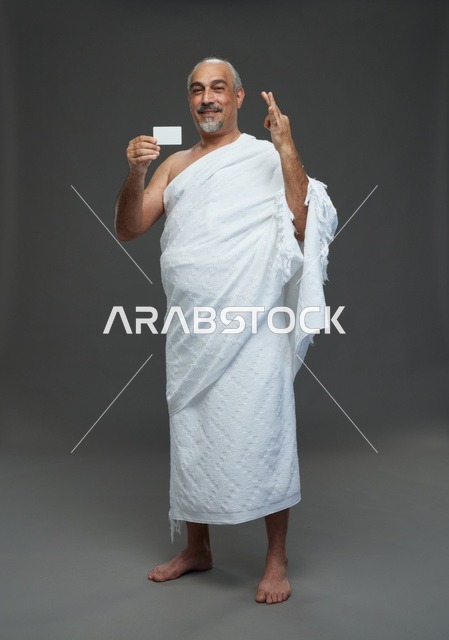 رجل سعودي بملابس الإحرام يحمل بطاقة فارغة