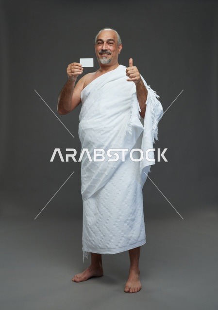 Saudi Man in Ihram Clothing Holding Blank Card Thumbs Up