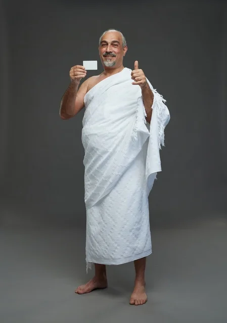 رجل سعودي بملابس الإحرام يحمل بطاقة فارغة وإبهامه للأعلى