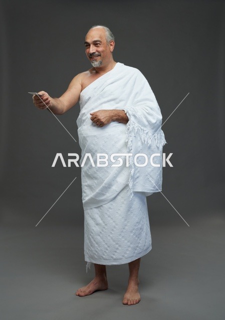 رجل سعودي بملابس الإحرام يحمل بطاقة فارغة