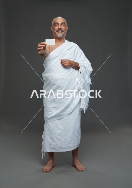 رجل سعودي بملابس الإحرام يحمل بطاقة فارغة