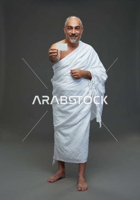 رجل سعودي بملابس الإحرام يحمل بطاقة فارغة