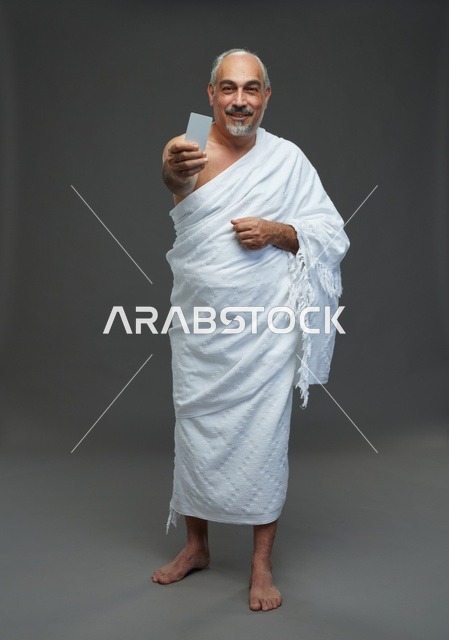 رجل سعودي بملابس الإحرام يحمل بطاقة فارغة