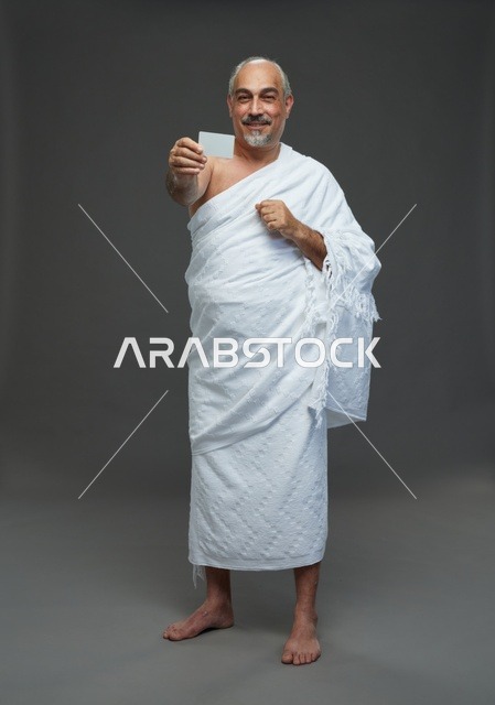 رجل سعودي بملابس الإحرام يحمل بطاقة فارغة