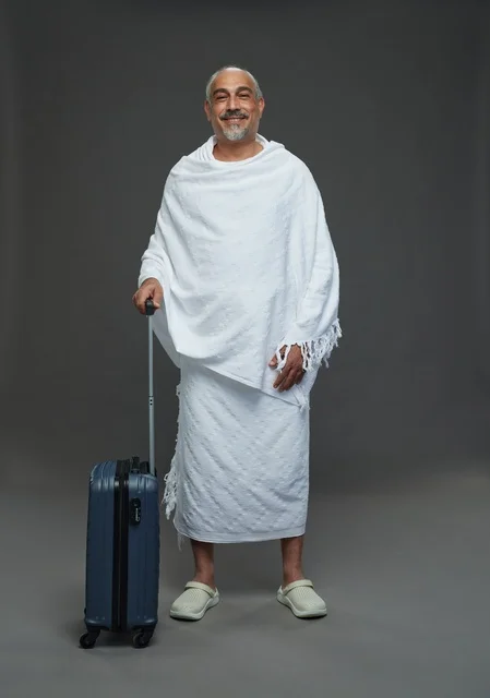 Saudi Man in Ihram Preparing for Hajj with Suitcase