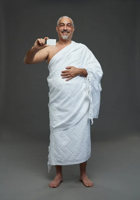 رجل سعودي بملابس الإحرام يحمل بطاقة فارغة في استوديو