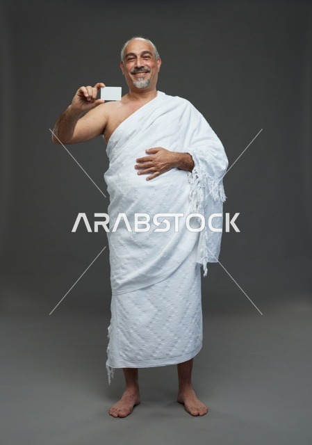 رجل سعودي بملابس الإحرام يحمل بطاقة فارغة