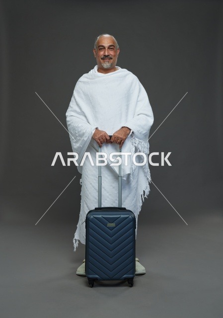 رجل سعودي بملابس الإحرام مع حقيبة سفر للحج والعمرة