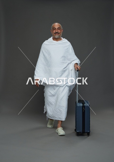 رجل سعودي بملابس الإحرام وحقيبة سفر للحج والعمرة