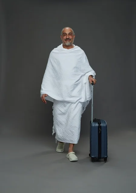 رجل سعودي بملابس الإحرام وحقيبة سفر للحج والعمرة