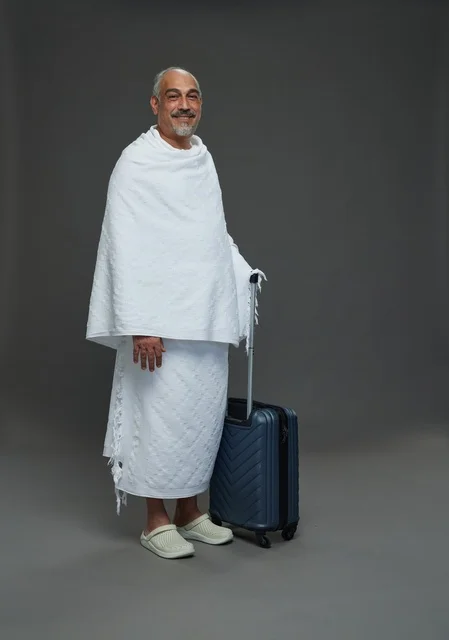 رجل سعودي بملابس الإحرام مع حقيبة سفر للحج والعمرة