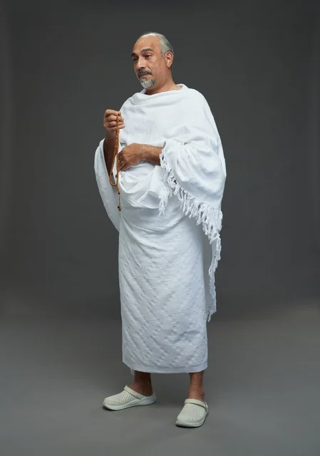رجل سعودي بملابس الإحرام يحمل سبحة لمناسك الحج