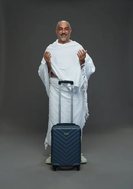 Saudi Man in Ihram with Suitcase Praying for Hajj