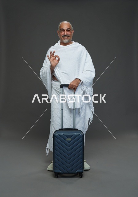 رجل سعودي بملابس الإحرام مع حقيبة سفر للحج
