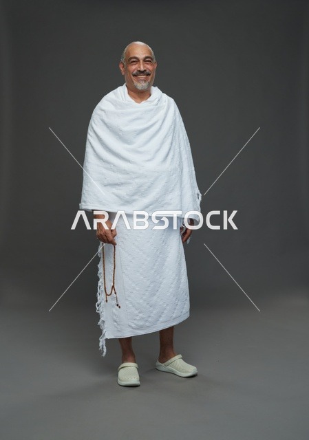 رجل سعودي بملابس الإحرام يمسك مسبحة في الاستوديو