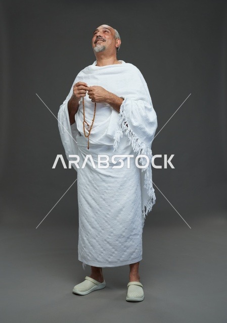 رجل سعودي بملابس الإحرام يمسك مسبحة