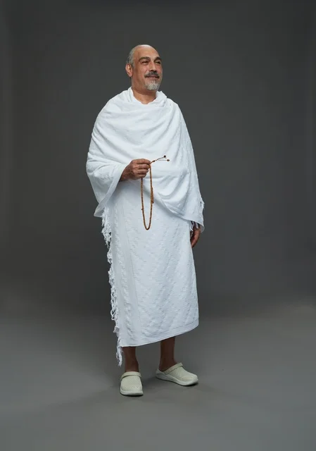 رجل سعودي بملابس الإحرام يحمل مسبحة في الاستوديو