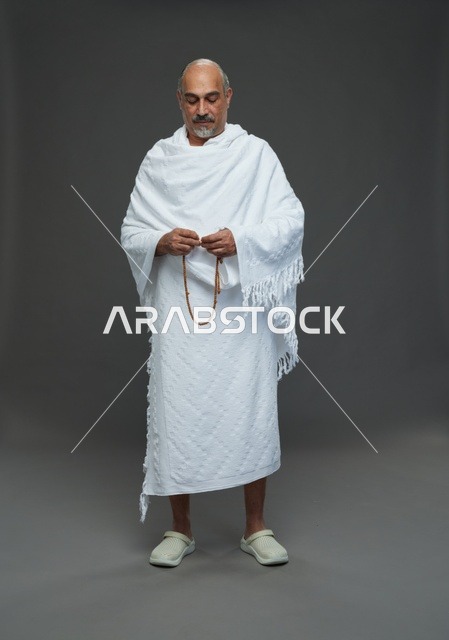 رجل سعودي بملابس الإحرام يمسك مسبحة