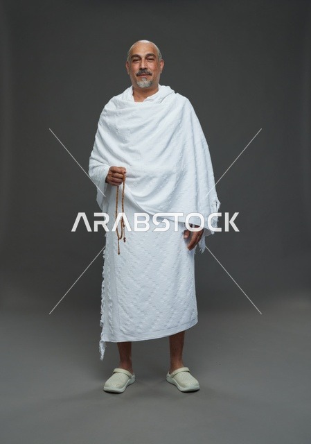 رجل سعودي بملابس الإحرام يمسك مسبحة أثناء أداء المناسك