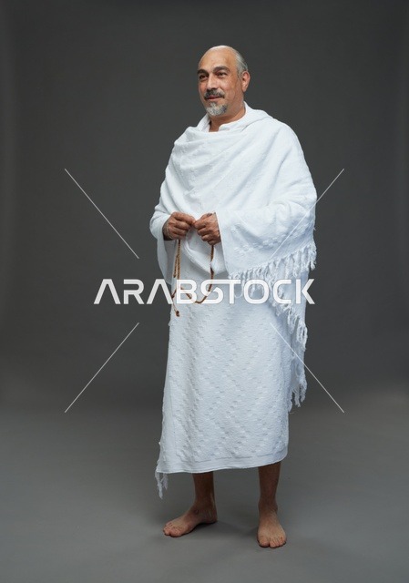 رجل سعودي بملابس الإحرام يمسك مسبحة لأداء مناسك الحج