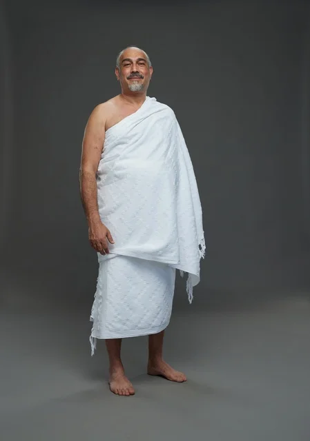 رجل سعودي مبتسم بملابس الإحرام أثناء أداء المناسك