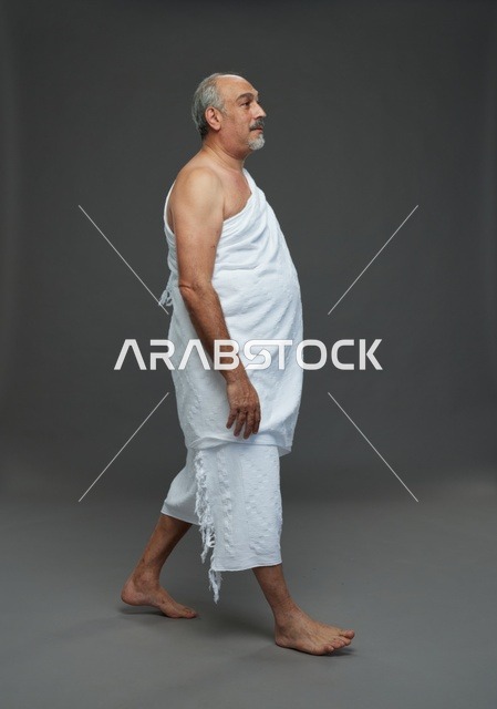 Saudi Man in Ihram Walking Against Grey Background Studio